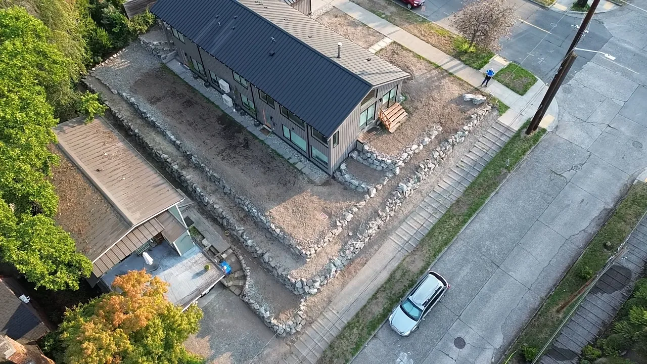 New construction lot after — full perimeter natural stone rockery walls