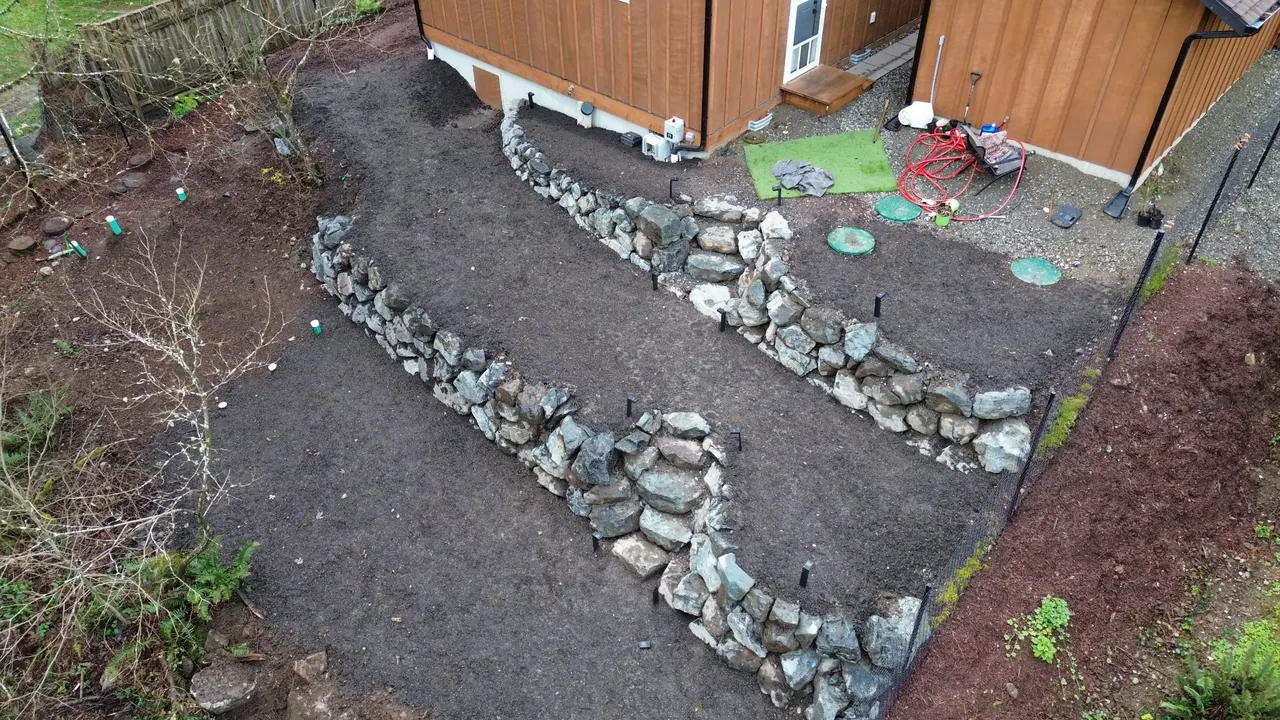 Aerial view after — terraced natural stone rockery walls with steps