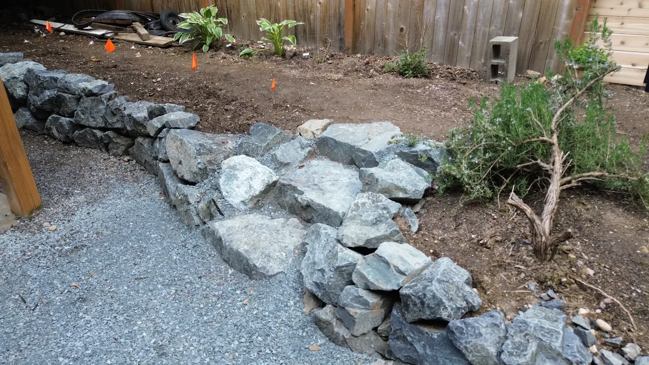 After — new natural stone rockery with clean gravel path