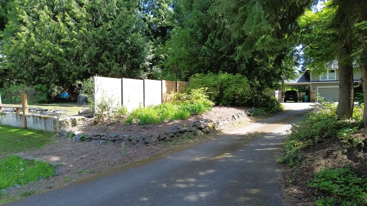 Driveway before — crumbling old rock walls along both sides