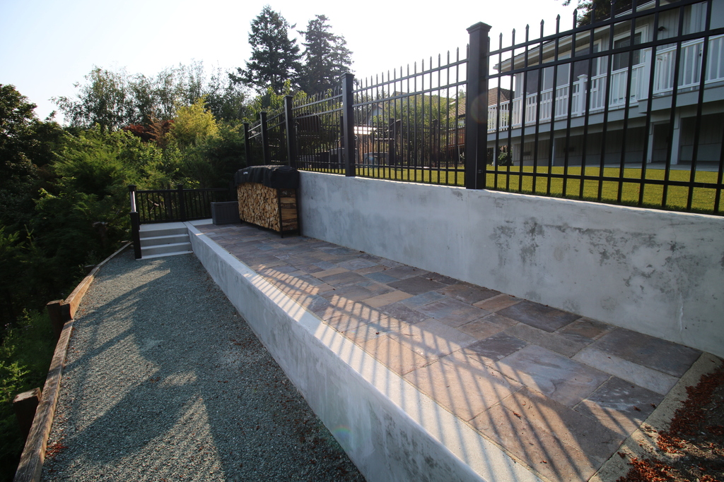 After — poured concrete retaining wall with natural stone paver patio