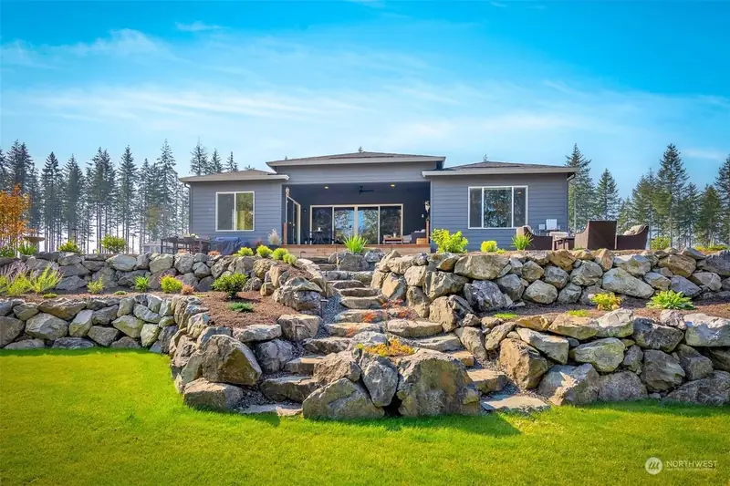 After — terraced natural stone rockery walls with steps and plantings