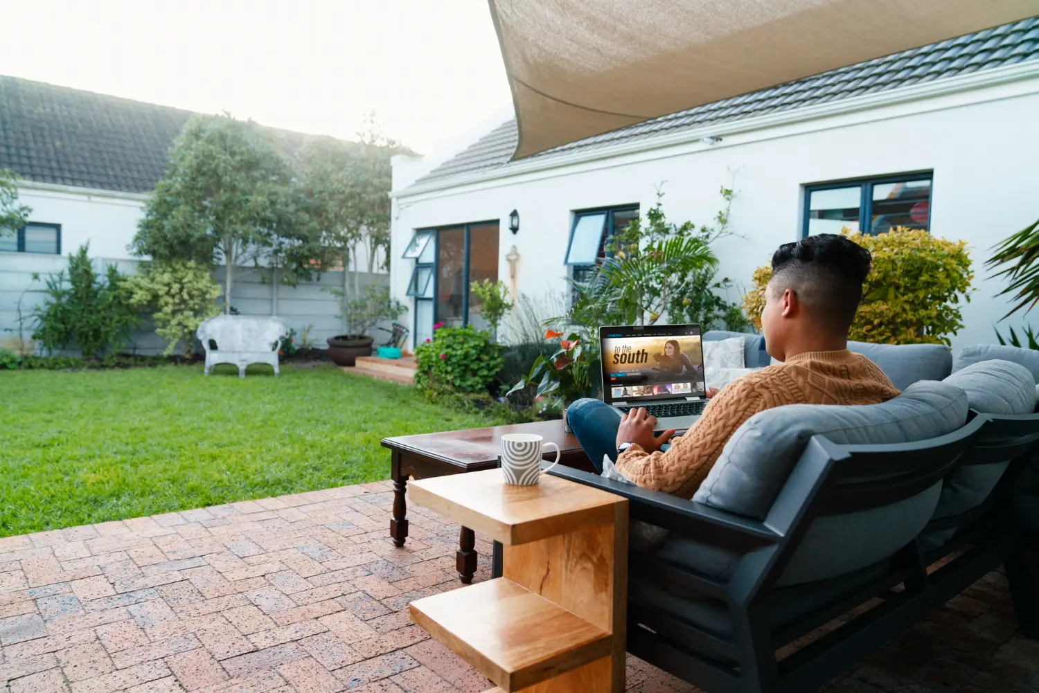 A man using a laptop Outdoor Living Spaces patio